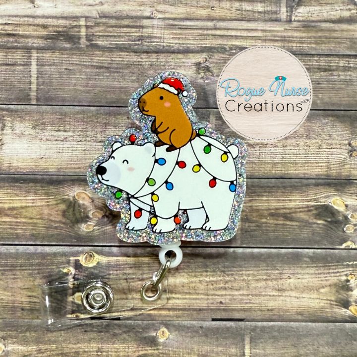 Capybara Riding a Polar Bear Decorated With Holiday Lights Wearing a Santa Hat Retractable Badge Reel, UV Printed on Silver Glitter Acrylic