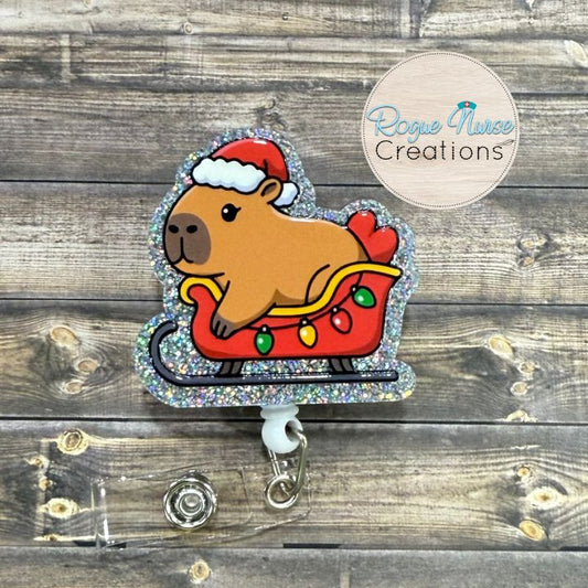 Capybara Wearing a Santa Hat, Riding Inside a holiday sleigh Retractable Badge Reel, UV Printed on Silver Glitter Acrylic