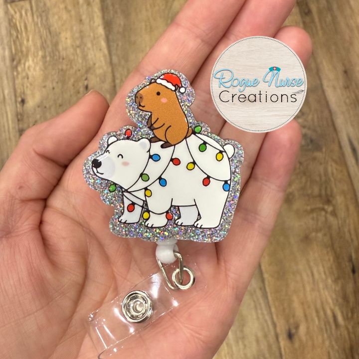 Capybara Riding a Polar Bear Decorated With Holiday Lights Wearing a Santa Hat Retractable Badge Reel, UV Printed on Silver Glitter Acrylic