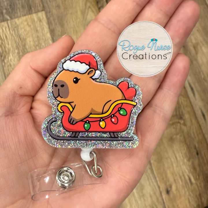 Capybara Wearing a Santa Hat, Riding Inside a holiday sleigh Retractable Badge Reel, UV Printed on Silver Glitter Acrylic