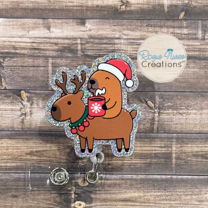 Capybara Riding a Reindeer Holding Hot Chocolate and wearing a Santa Hat Retractable Badge Reel, UV Printed on Silver Glitter Acrylic