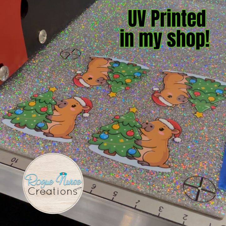 Capybara decorating a Christmas Tree Wearing a Santa Hat Retractable Badge Reel, UV Printed on Silver Glitter Acrylic